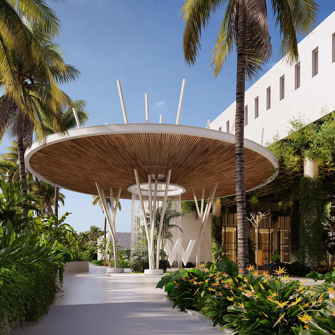 A modern resort entrance with a large circular wooden canopy supported by white columns, surrounded by lush tropical plants, palm trees, and a beige building in the background under a clear blue sky.